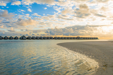 Landscape of beautiful sunset in Maldives island sandy beach with colorful sky over wavy sea