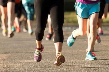 Runners legs at a 5K on a dirt psth