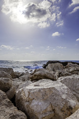 Fototapeta na wymiar Vertical seascape with big rocks at Caesarea national park coast high sun and blue sky