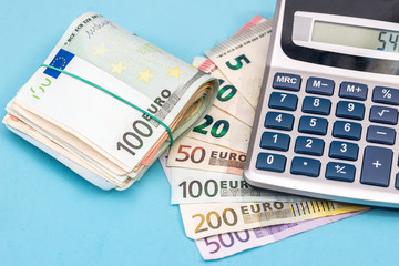 euro banknote with calculator on blue background. close up