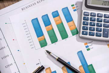 analyzing investment charts with laptop on desk.