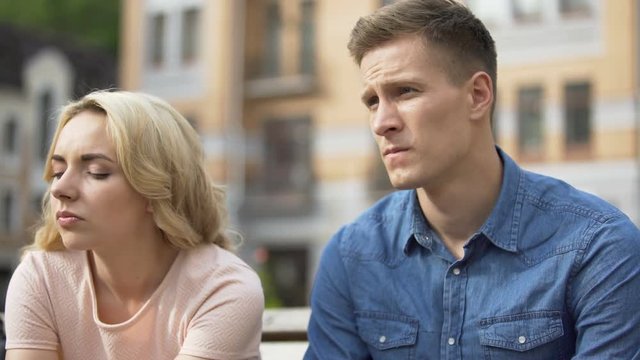 Guy and girl sitting next to each other, gloomy faces, first fight, relationship