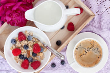 Breakfast with coffee, granola, berries and milk