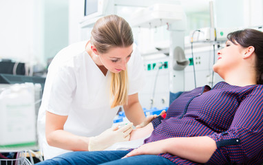 Nurse applying access for blood drawing and shots at upper arm of patient