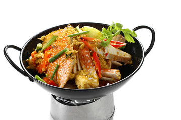 Stir fried Blue Swimming Crabs (Portunus pelagicus) with Yellow Curry Powder in Black Pan Isolated on White Background, Top Front View. Popular Thai Food. Selective Focus at the front.