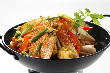 Stir-fried Fresh Blue Crabs (Portunus pelagicus) with Yellow Curry Powder in Black pan Isolated on White Background, Top Side View. Traditional Asian Food. Close up & Selective Focus at the front.