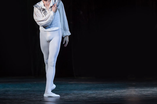 Outfit, Choreography, Amusement Concept. Dazzling White Figure Of Male Ballet Dancer Wearing Shirt With Needlework, Tights And Pointe Shoes Dancing On The Dark Stage All Alone