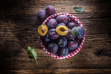 Plums. Fresh juicy plums in a bowl on a wooden or concrete board.
