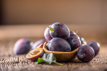Plums. Fresh juicy plums in a bowl on a wooden or concrete board.