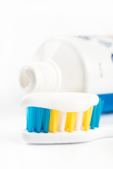 Toothpaste on toothbrush in closeup macro with toothpaste in the background