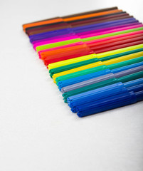 Fototapeta premium a lot of colored pencils, markers, pens, white background, row markers colored yellow, blue, red, concept, school, business, office, creativity, search ideas