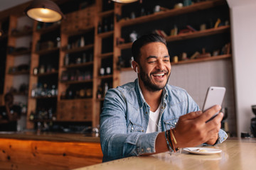 Young man making a video call at cafe