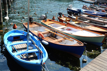 Fototapeta na wymiar Colorful small boats and ducks in touristic port of Sulzano, Italy