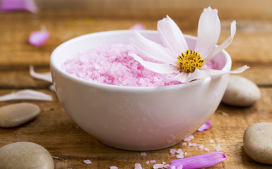 Obraz na płótnie Canvas Spa bath salt bowl with flower.Pink bath salt wellness composition