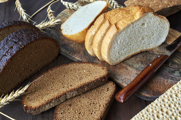 Assortment of baked bread on wooden table background