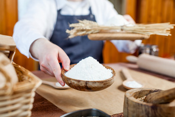 Man holding wheat flour in a bakery close up