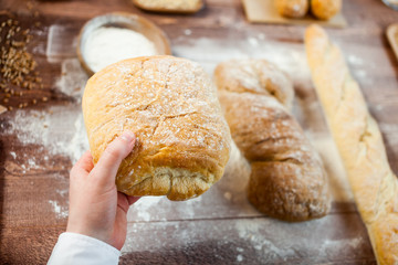 Baker man holding a beautiful fresh bread