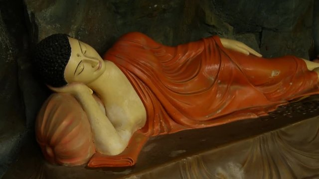 Tilt from a group little buddhas to a laying buddha at the Ranawana Temple