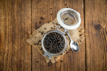 Black Peppercorns, preserved, on wooden background