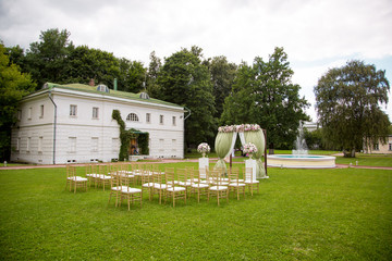 Beautiful wedding ceremony outdoors. Decorated chairs stand on the grass. rustic style.
