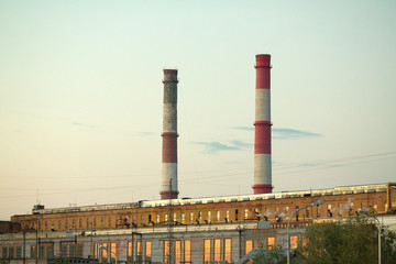 Production plant against the sky with pipes for the exhaust of waste in the form of smoke