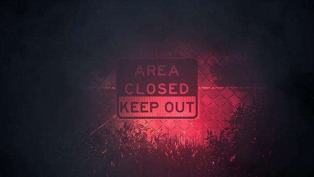 AREA CLOSED KEEP OUT Signs on a Metal Fence in a Storm