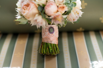 Elegant wedding flower bouqet on texture green sofa close-up