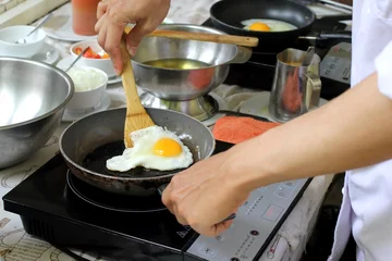 Tableaux sur verre Oeufs sur le plat chef cuisinant des œufs au plat