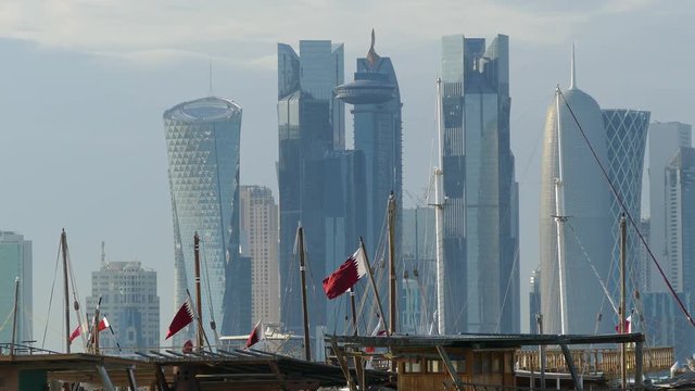 Traditional Dhow, Arab sailing vessels with Qatar flags in the Dhow Harbour with the Doha skyline in the background