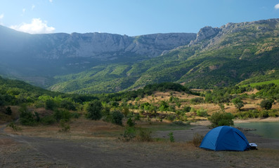 Blue tent on the shore of a mountain lake