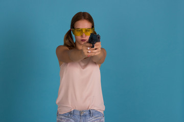 Young pretty girl with weapon, studio  