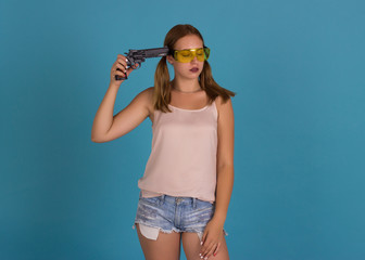 Young pretty girl with weapon, studio  