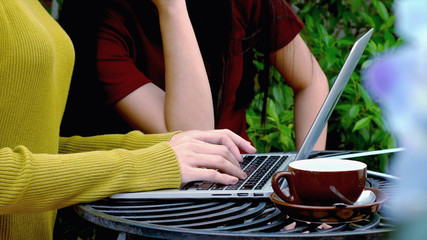 Young femal hand typing on keyboard of laptop computer