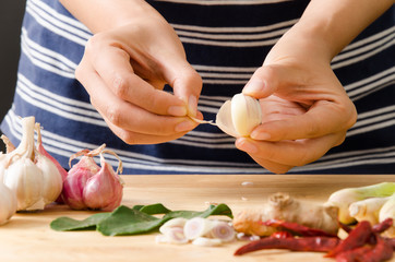 Woman peeling garlic and prepare food ingredients for Thai food cooking © nungning20