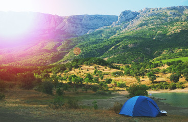 Blue tent on the shore of a mountain lake