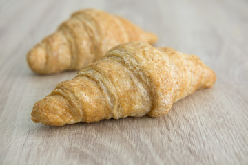 CROISSANT
Two brown croissant on the wood table. 