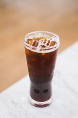 Ice coffee americano on the white mable table soft focus