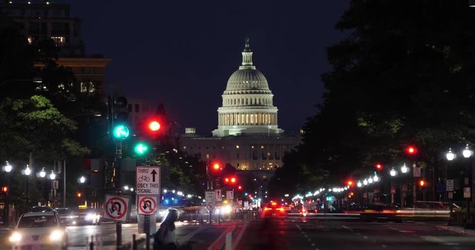 A night time lapse view of traffic activity on Pennsylvania Avenue in Washington, D.C. with the Capitol Dome in the distance.  	
