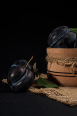 Garden plums in bowl on stone table. View with copy space