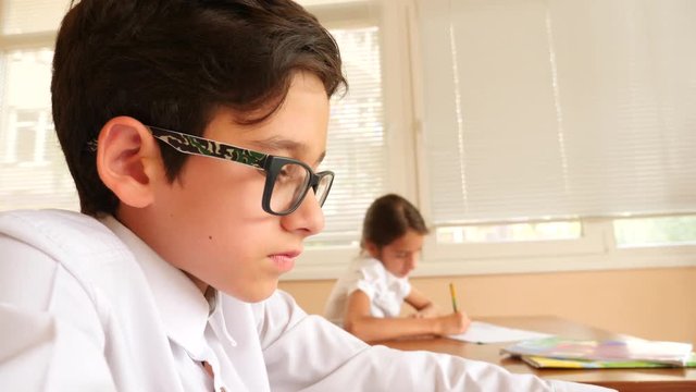 education, people and learning concept - group of students with notebooks writing test at school. 4k. Slow motion