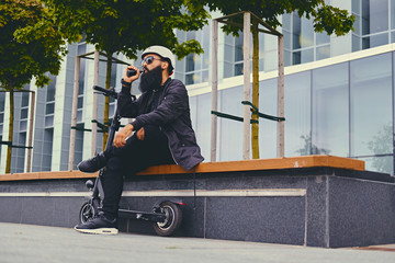A man vaping after electric scooter.
