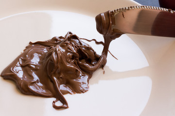 chocolate hazelnut spread on plate with knife. Close up
