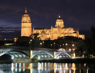 Fototapeta na wymiar Salamanca skyline at night and Enrique Esteban Bridge over Tormes River in Spain