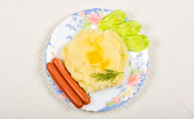 Mashed potatoes with sausages and cucumber slices