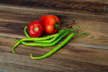 Green chilli pepper on a wooden background