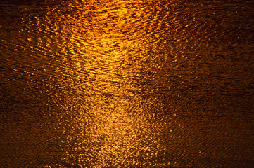 Fototapeta na wymiar Liquid gold water surface texture at sunset on Ada lake in Belgrade, Serbia