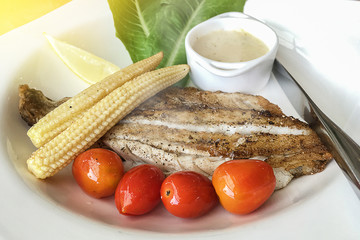 Homemade hot and fresh dory fish steak with green vegetable and white wine sauce.