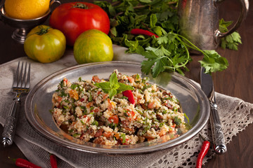 Tabbouleh - Middle Eastern vegetarian dish with couscous, tomatoes, parsley, dried raisins and mintseasoned with olive oil and lemon juice. Easy authentic recipe