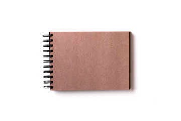 Horizontal aligned isolated sketchbook with blank brown craft paper on white background. Top view, flat lay.