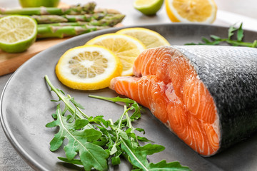 Fresh salmon fillet with arugula and lemon on plate